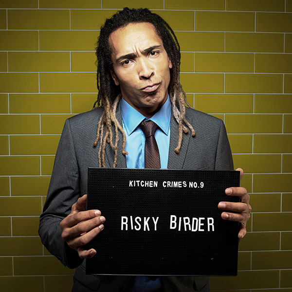 Mock mug shot photograph of a man holding a sign saying kitchen crimes number 9: risky birder